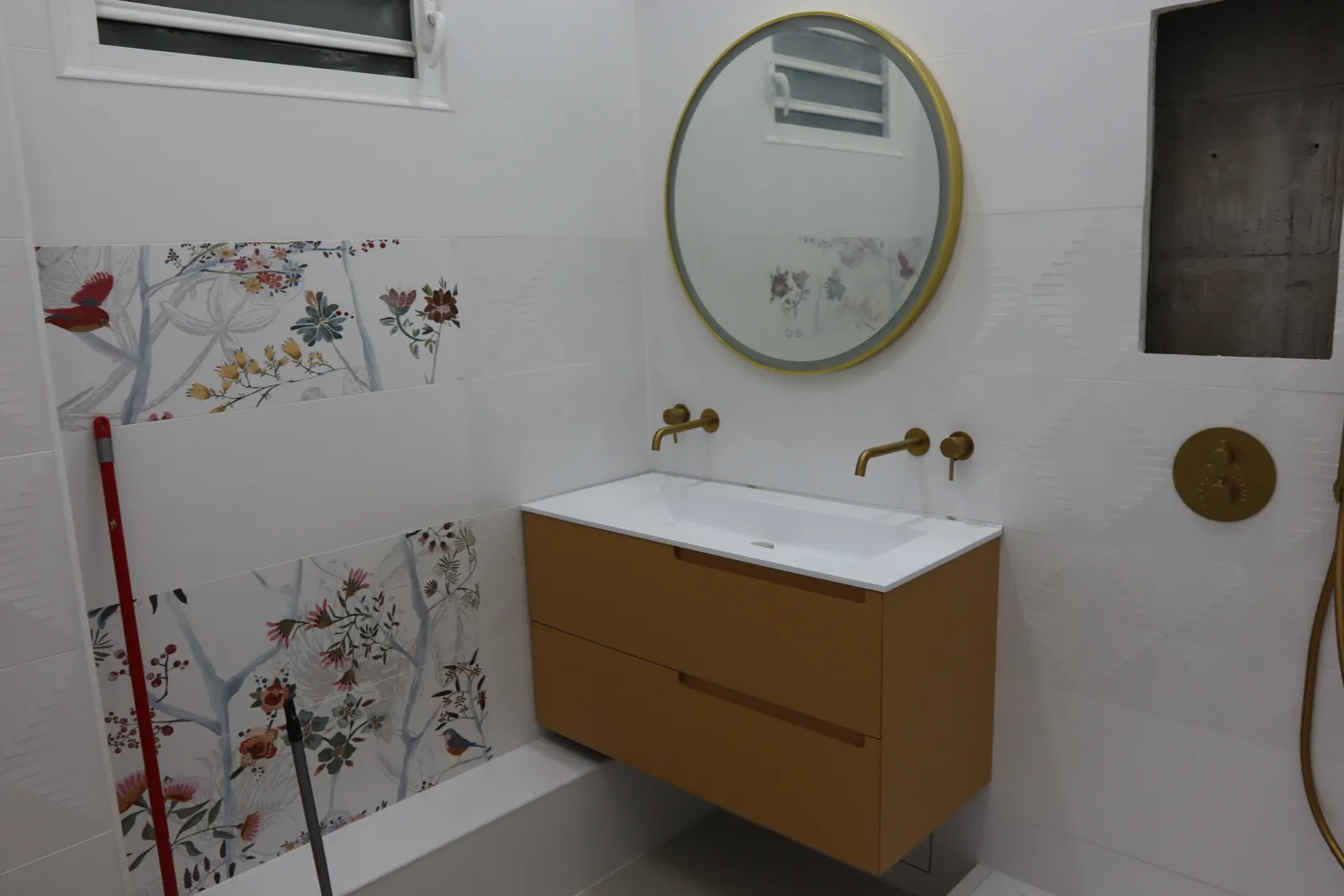 Salle de bain terminée : meuble vasque suspendu et miroir rond