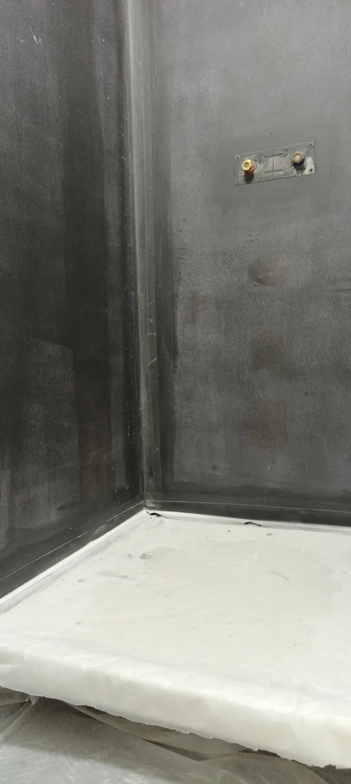Étanchéité sous carrelage appliquée sur les murs de la douche