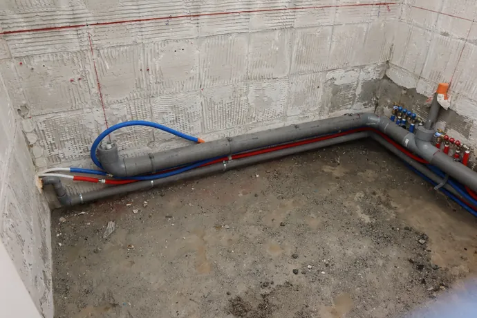 Alimentations en eau chaude et eau froide en tubes PER posées le long d’un mur avant habillage