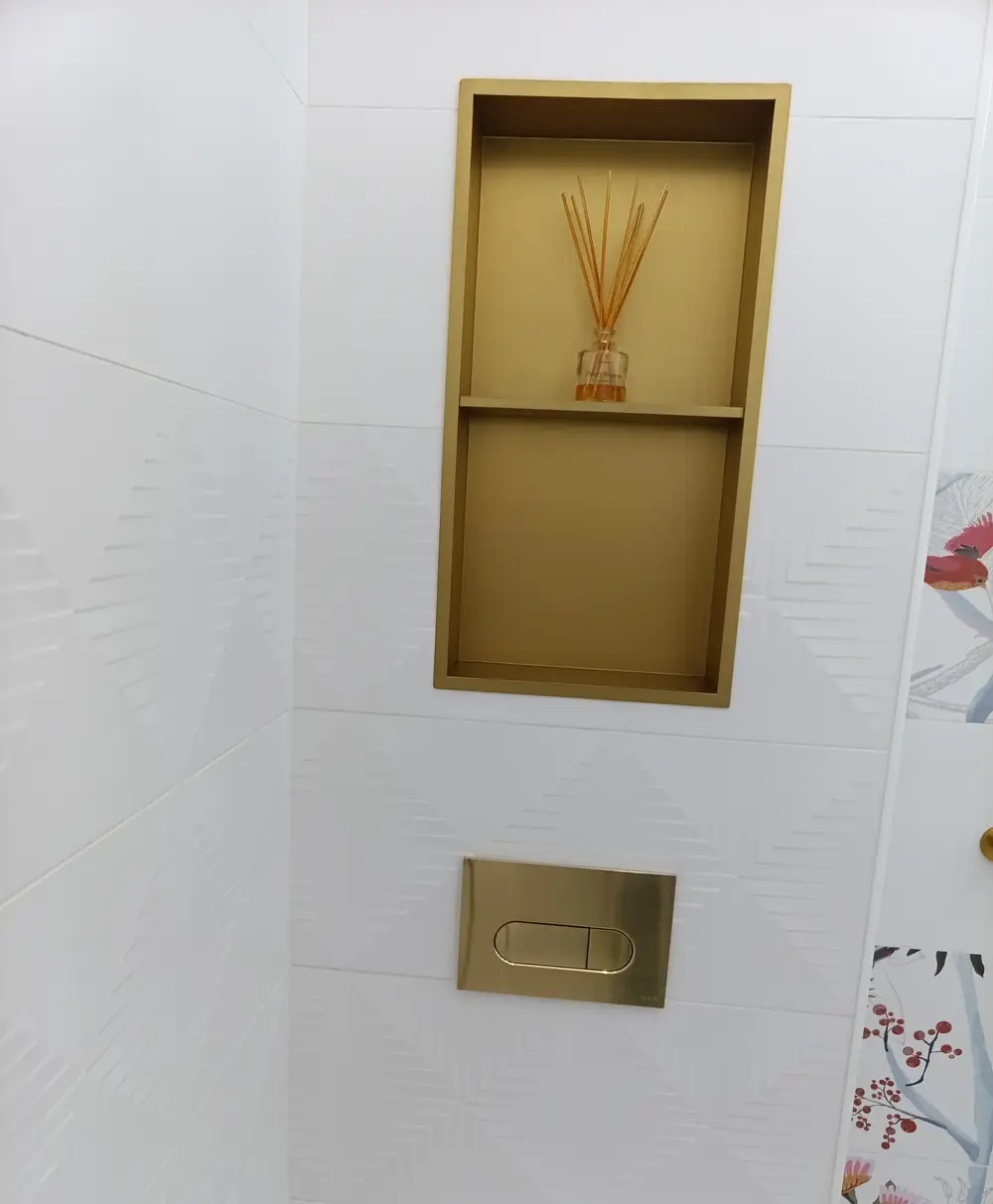 Niche encastrée dorée au-dessus d'une plaque de commande de WC suspendu en Guadeloupe
