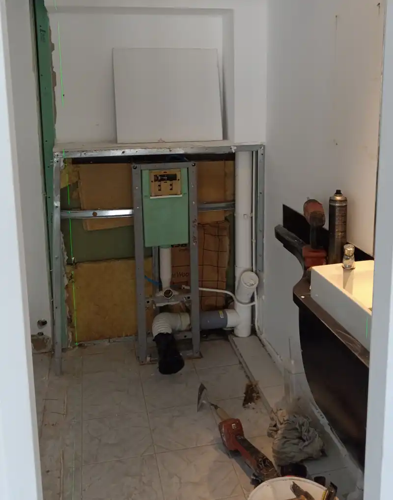 Bâti-support de WC suspendu en place et évacuations reprises après dépose des cloisons, en Guadeloupe